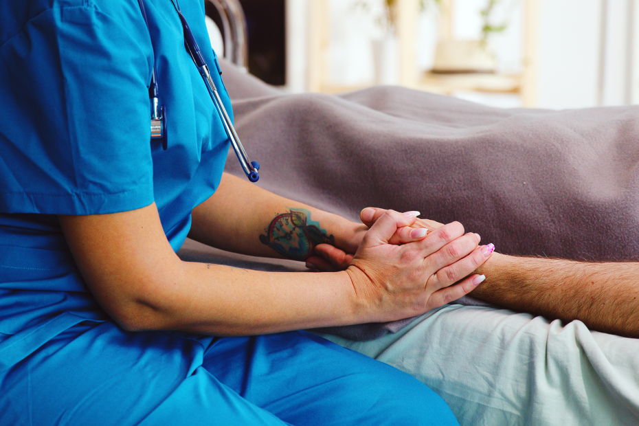 Pflegekraft hält die Hand eines Patienten
