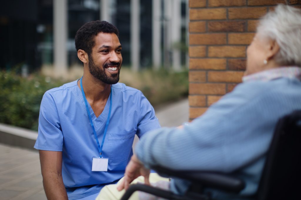 Pfleger mit Frau im Rollstuhl